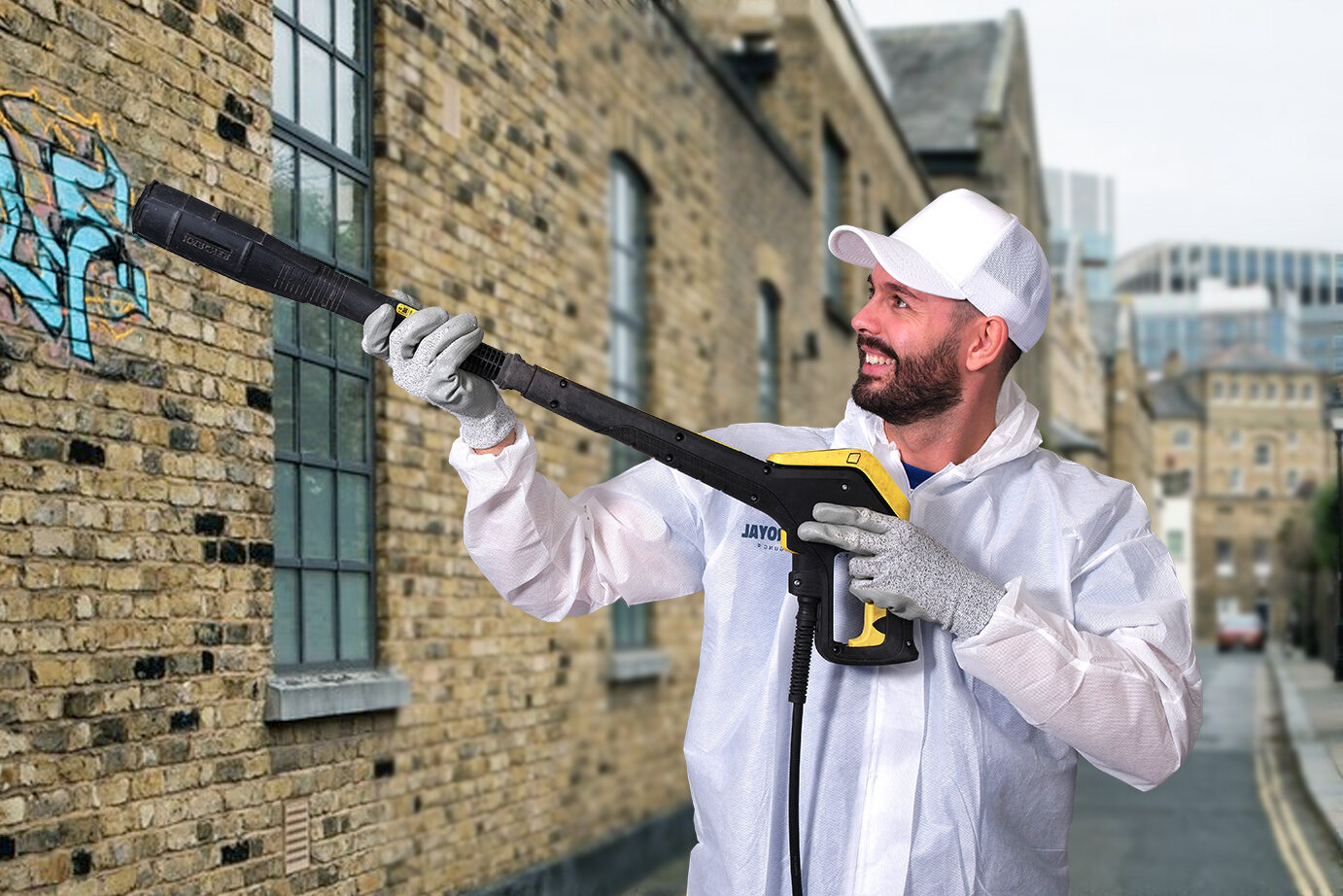 Ein Mitarbeiter der Graffitientfernung in Nürnberg in einem weissen Anzug mit Hochdruckreiniger