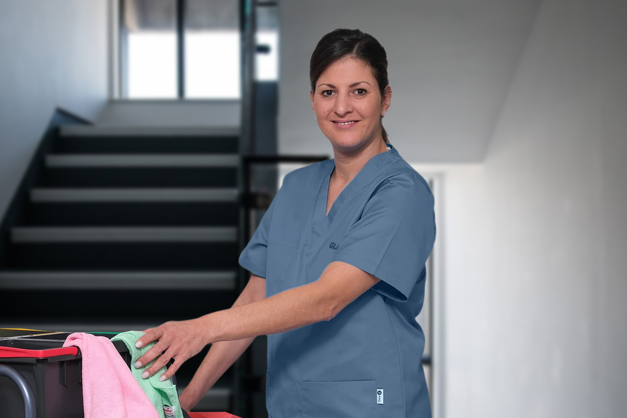 Eine Mitarbeiterin der Treppenhausreinigung in Nürnberg mit einem Reinigungswagen